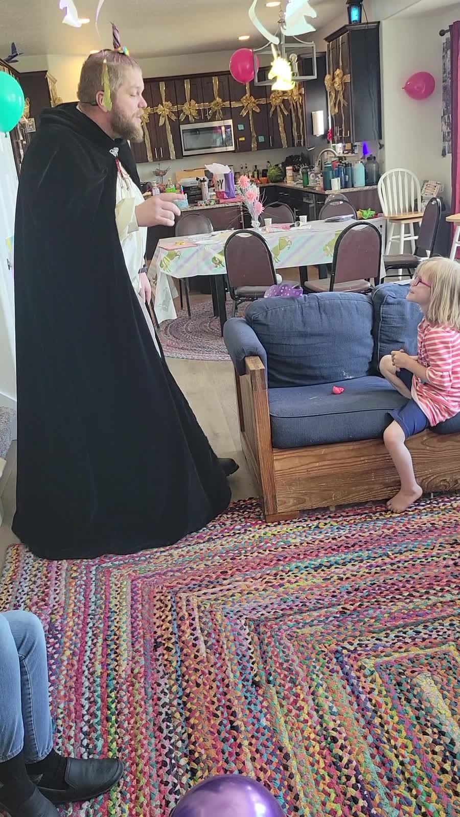 Cloaked storyteller performing at a decorated birthday party